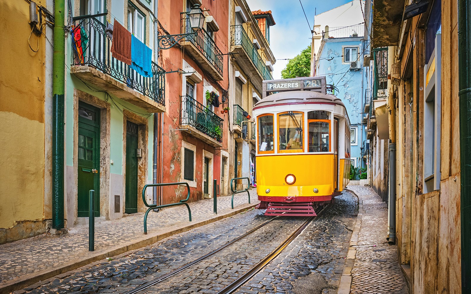 Tram 28 navigating a narrow street in Lisbon, Portugal.
