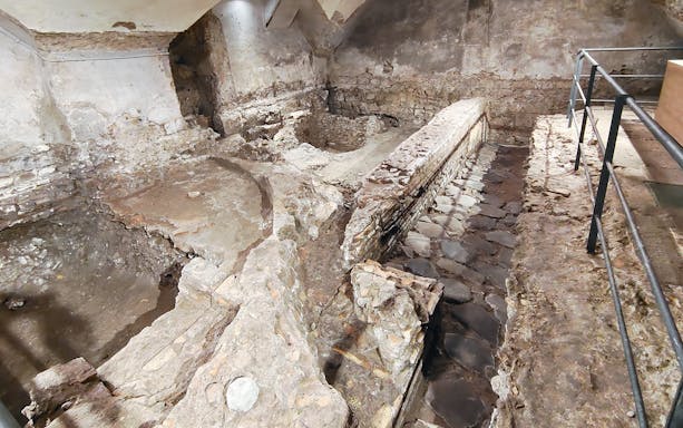 Excavated ancient stone walls and pathways beneath Basilica of San Marco, Rome.