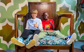 Visitors sitting on oversized chair at Big Fun Museum, Barcelona exhibit.