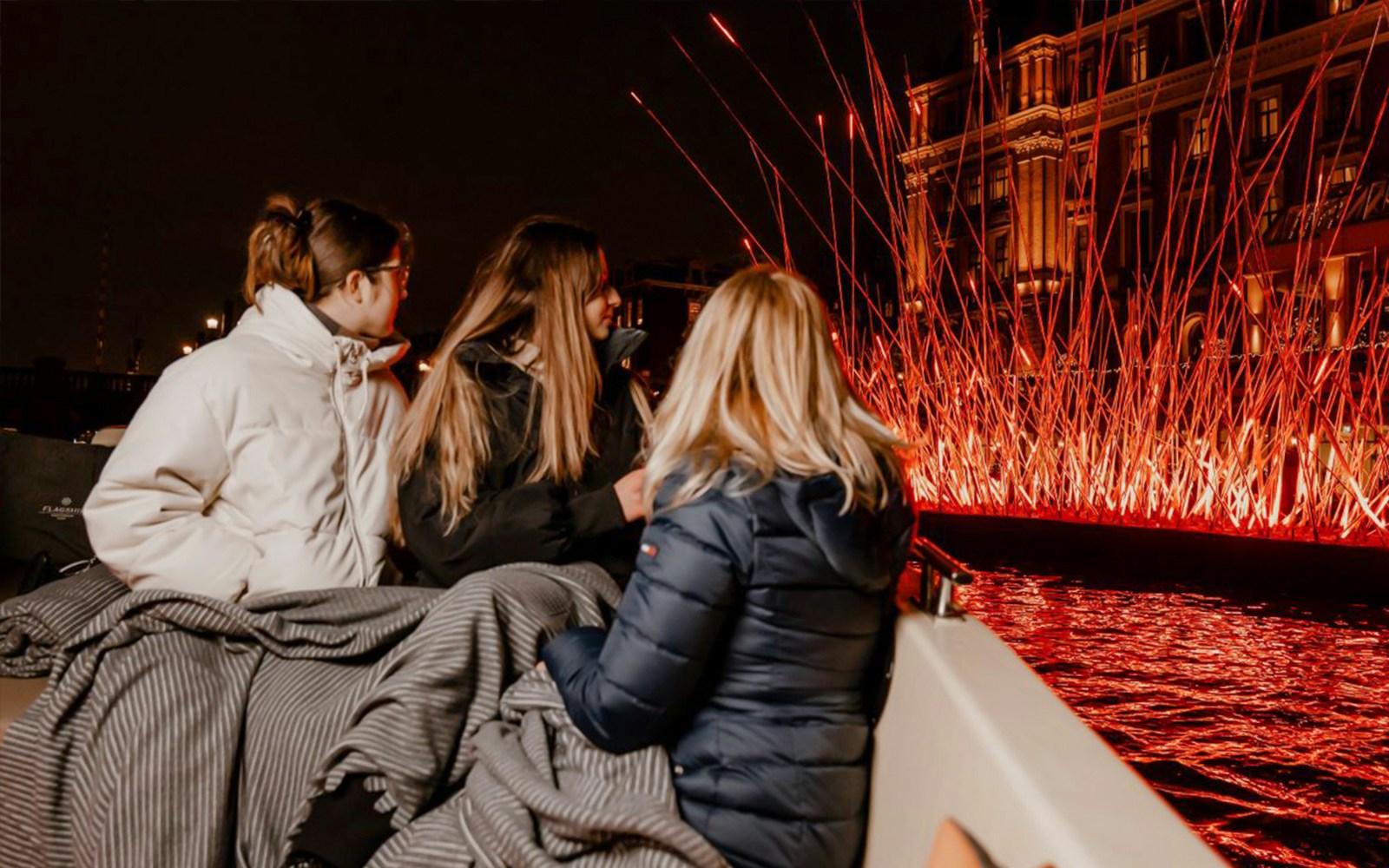 Amsterdam canal cruise showcasing vibrant Light Festival installations.