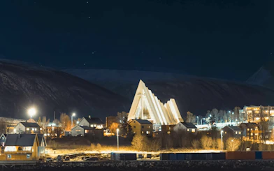 Tromsø's Arctic Cathedral illuminated at night during an Aurora Boreal dinner cruise.