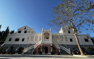 White colonial-style building with arched windows at Bac Ha Market, Vietnam.