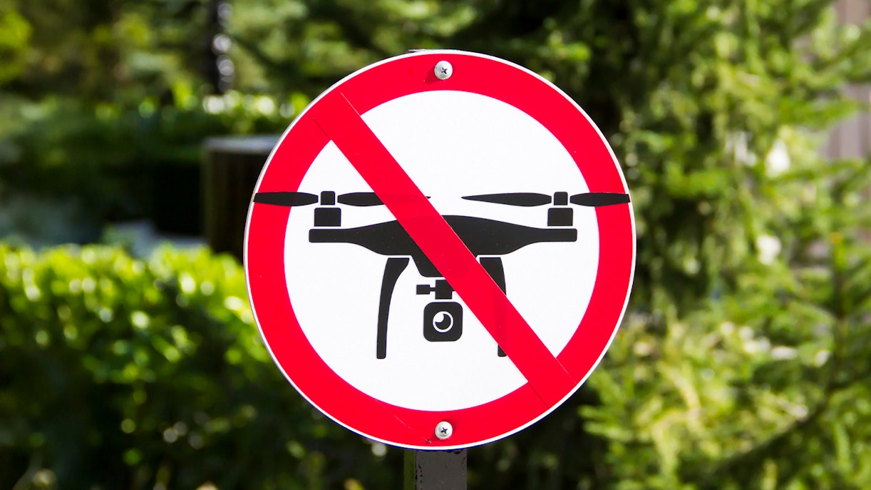 No drone flying sign in a park setting.