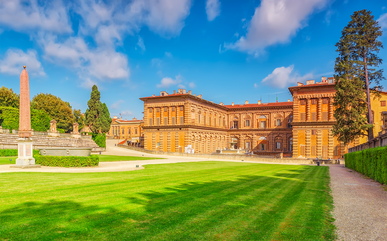 Visitors exploring the historic Boboli Gardens in Florence, Italy, surrounded by lush greenery and classical sculptures.
