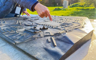 Guide pointing at Plaszow Concentration Camp model during Krakow historical tour.