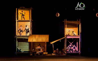 Performers in bamboo structures at AO Show tableaux.