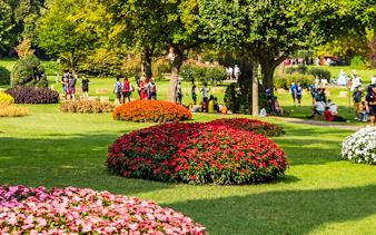Visitors enjoying the roses garden at Parco Giardino Sigurtà with vibrant flower beds.