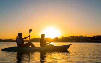 Kayakers paddling at sunset on Surfers Paradise Guided Kayak Tour, Gold Coast.
