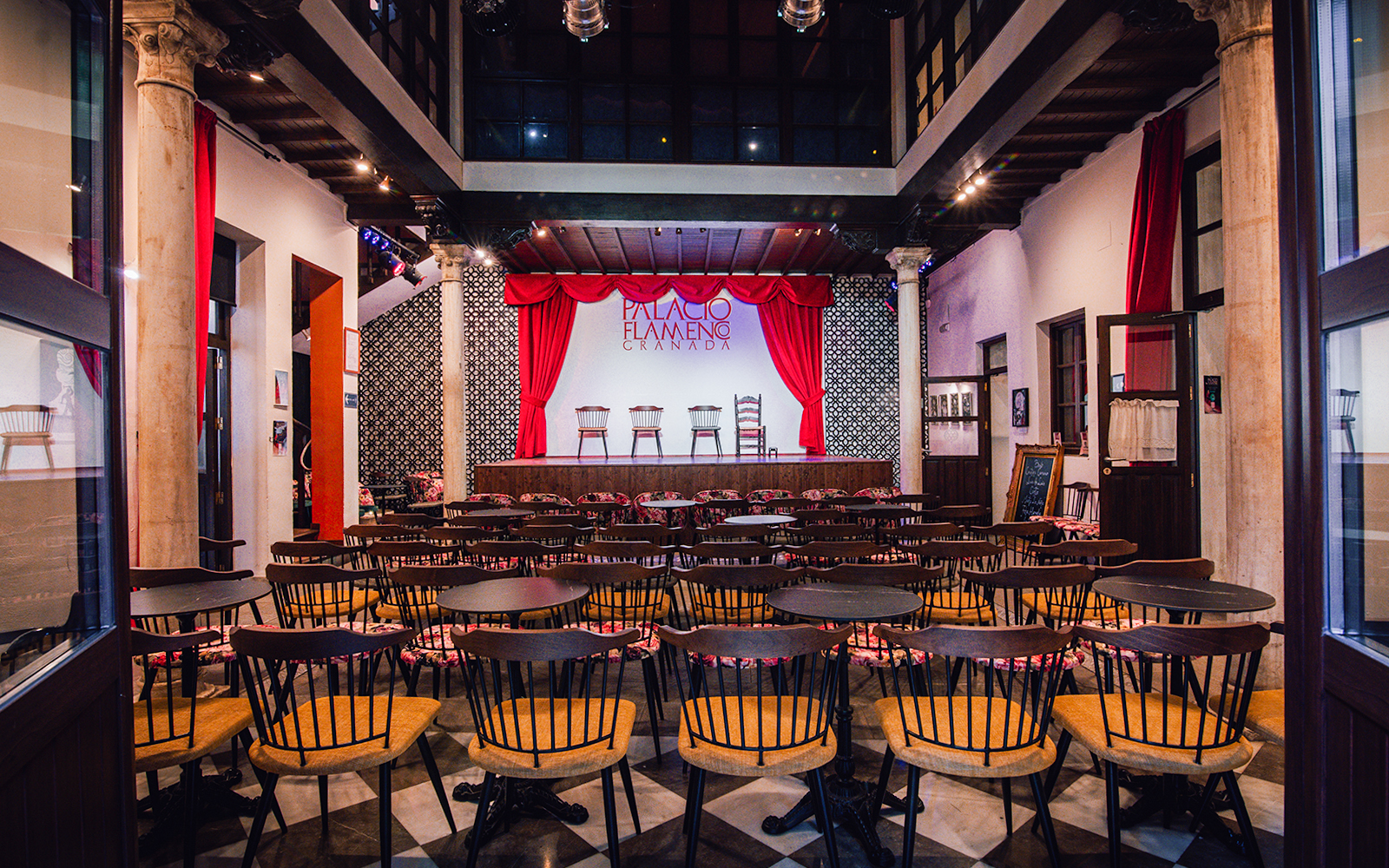 Palacio Flamenco Granada stage with red curtains and seating area.