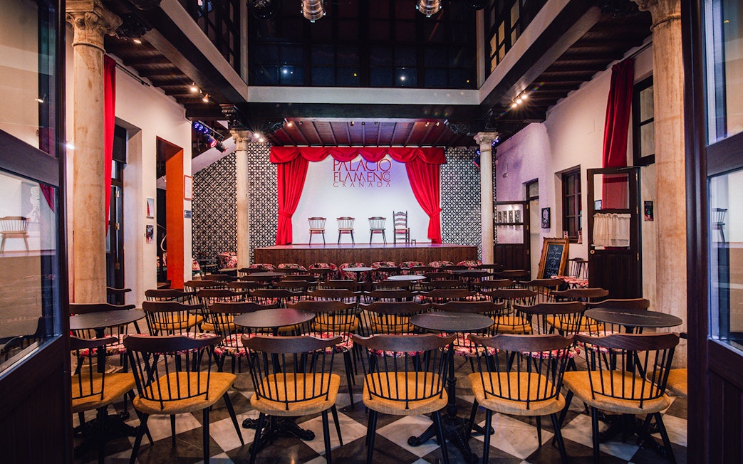 Palacio Flamenco Granada stage with red curtains and seating area.