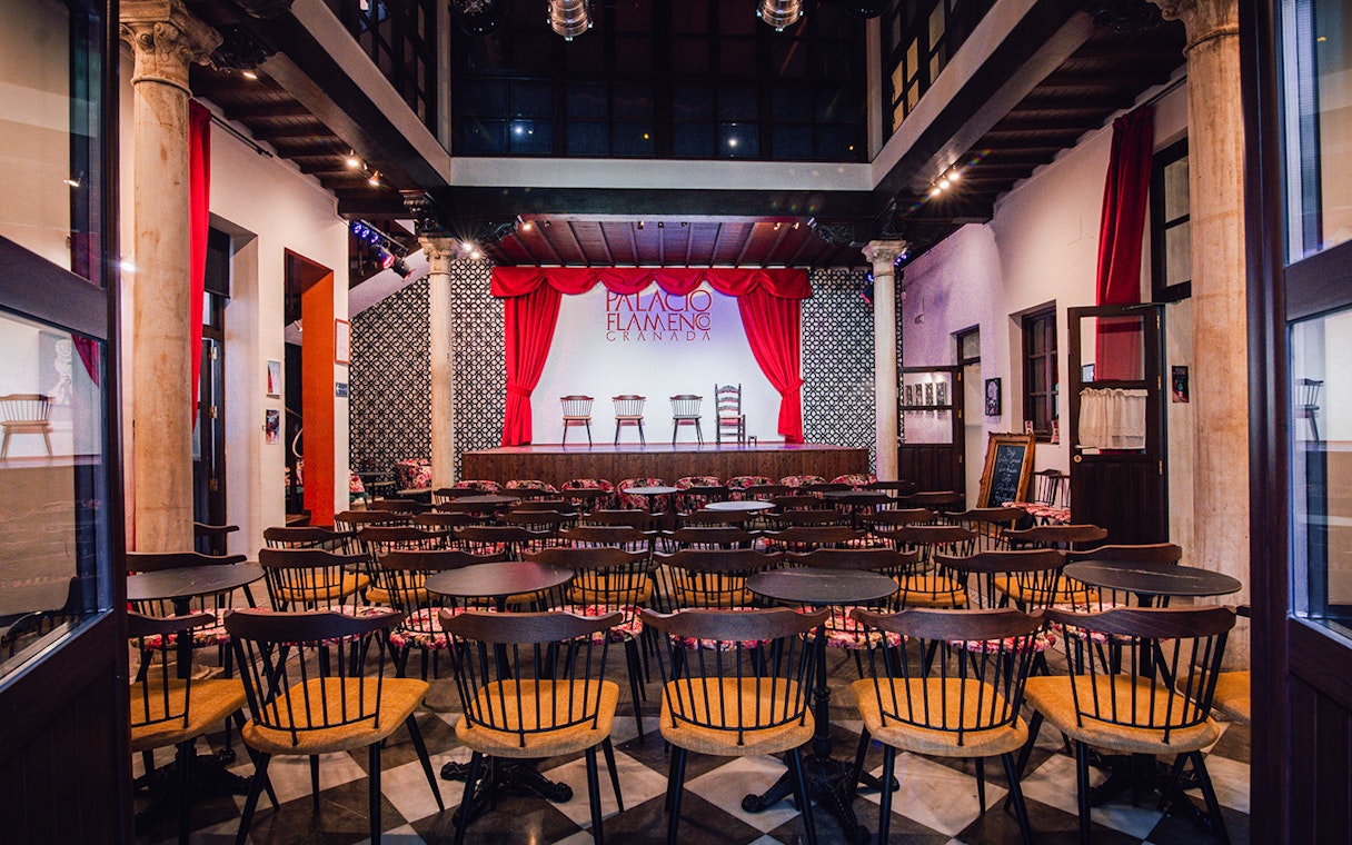 Palacio Flamenco Granada stage with red curtains and seating area.