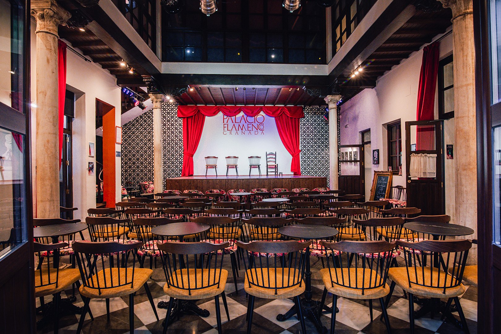 Palacio Flamenco Granada stage with red curtains and seating area.