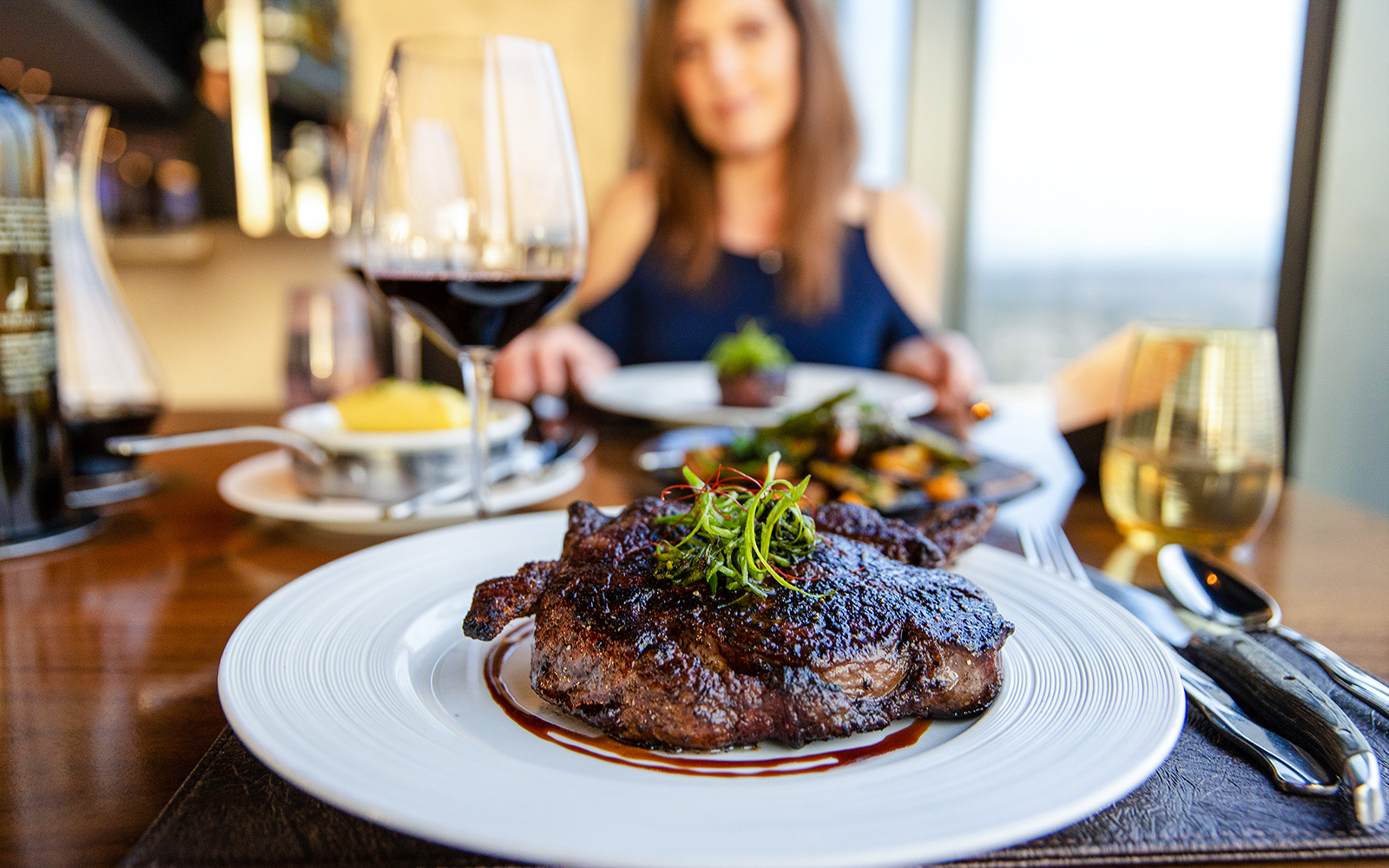 Gourmet grilled ribeye steak with red wine served at a fine dining restaurant in Paris, France.
