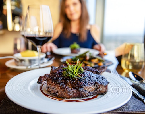 Gourmet grilled ribeye steak with red wine served at a fine dining restaurant in Paris, France.