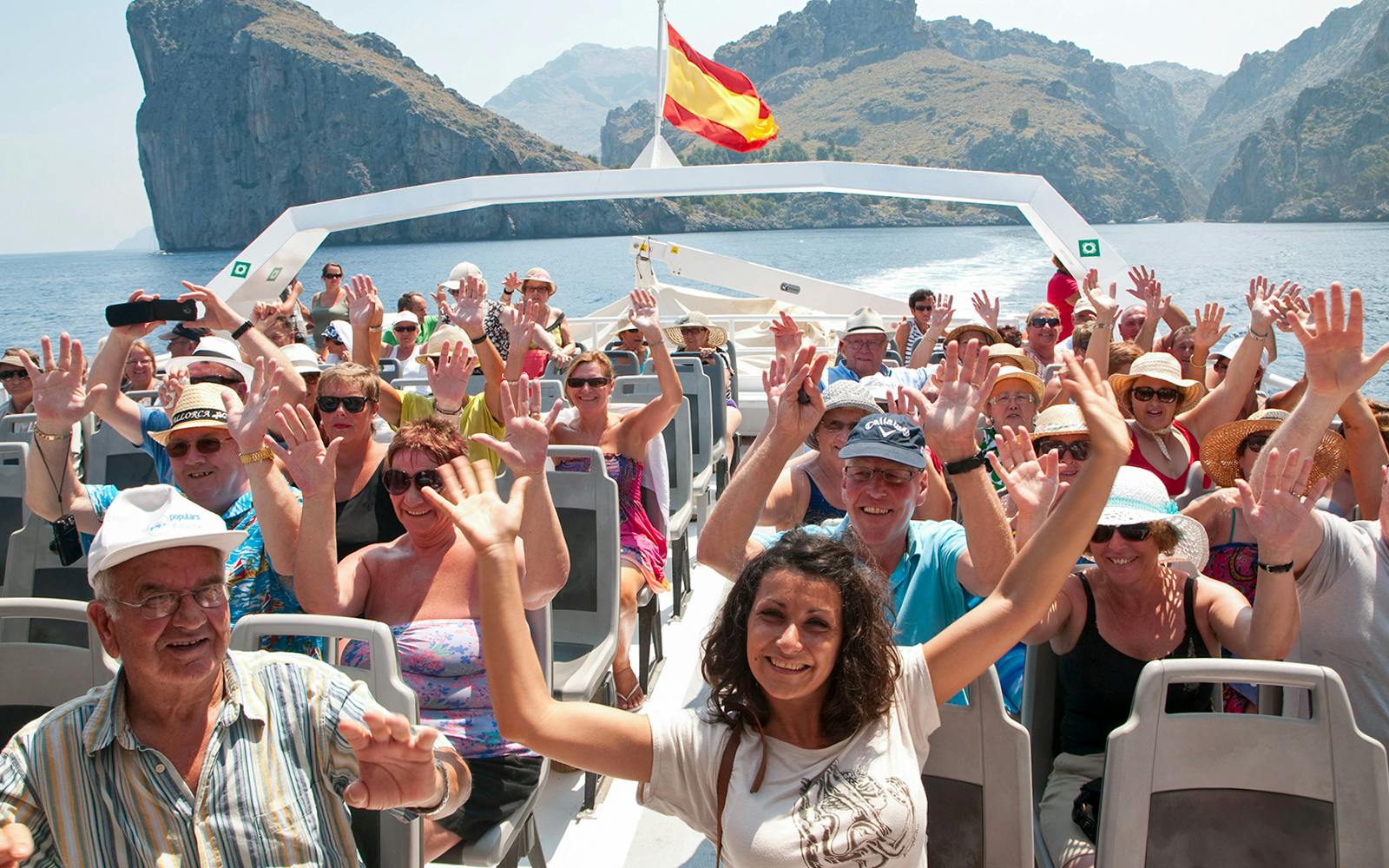 Tourists enjoying a boat ride with scenic views of Mallorca's coastline.
