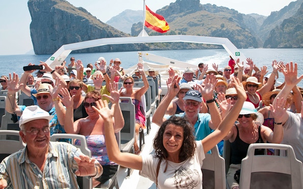 Tourists enjoying a boat ride with scenic views of Mallorca's coastline.