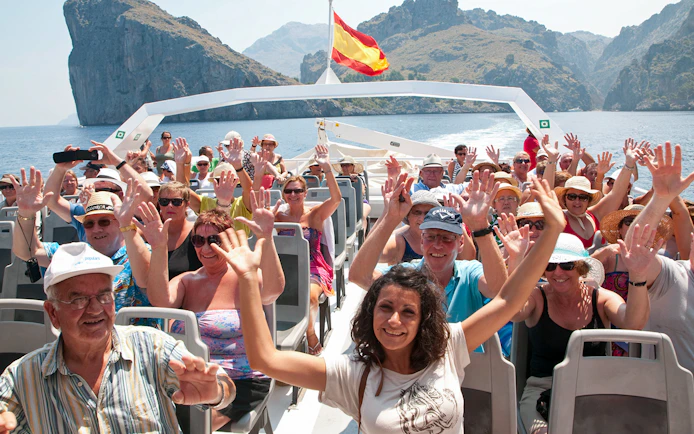 Tourists enjoying a boat ride with scenic views of Mallorca's coastline.
