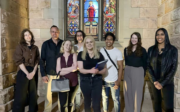 Group of people on Brisbane's True Crime Stories tour in front of a stained glass window.