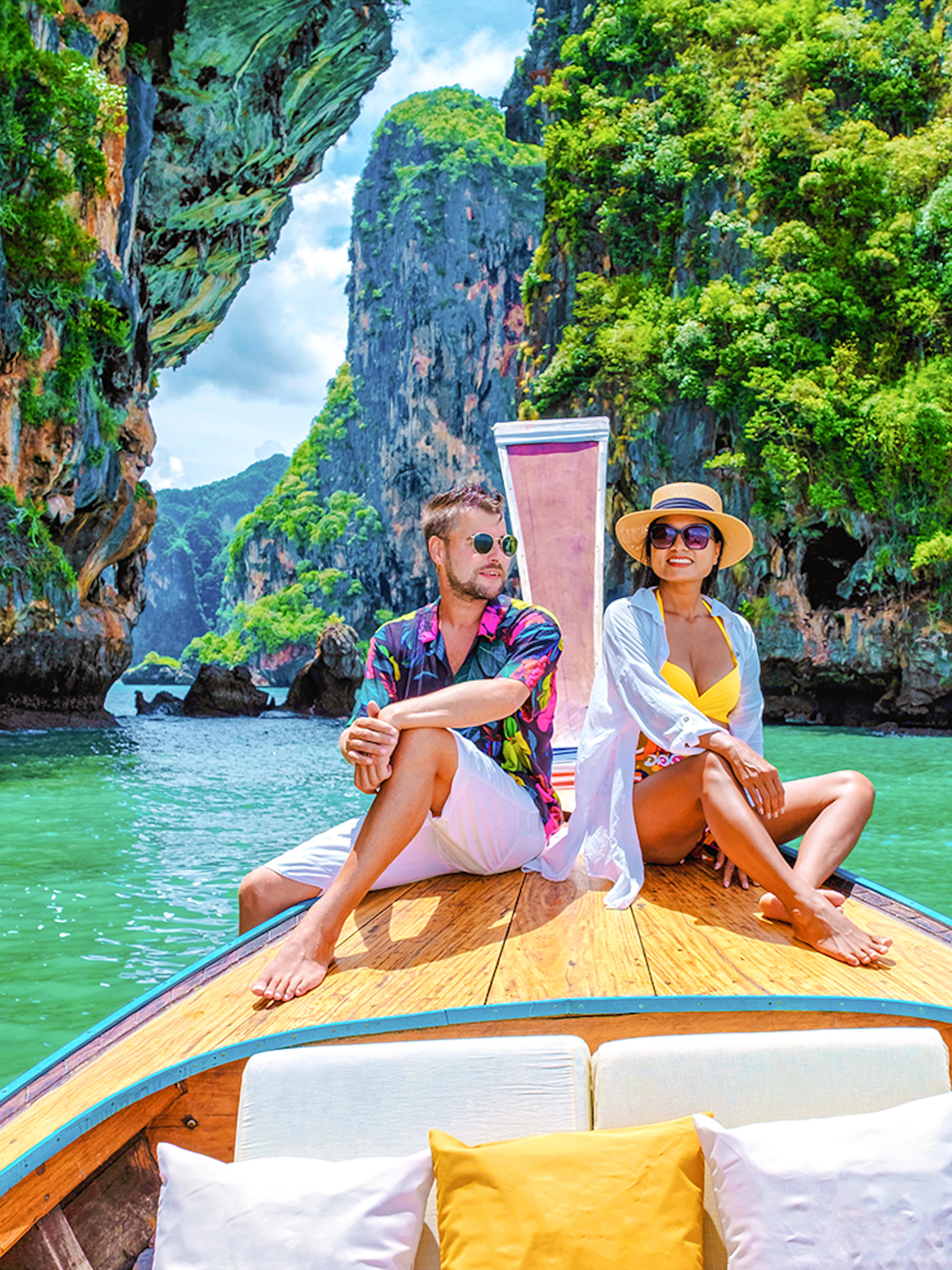 Longtailed boat tour through limestone cliffs in Krabi, Thailand.