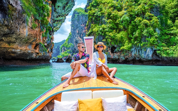 Longtailed boat tour through limestone cliffs in Krabi, Thailand.
