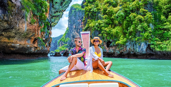 Longtailed boat tour through limestone cliffs in Krabi, Thailand.