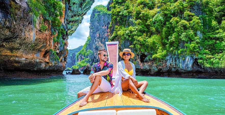 Longtailed boat tour through limestone cliffs in Krabi, Thailand.