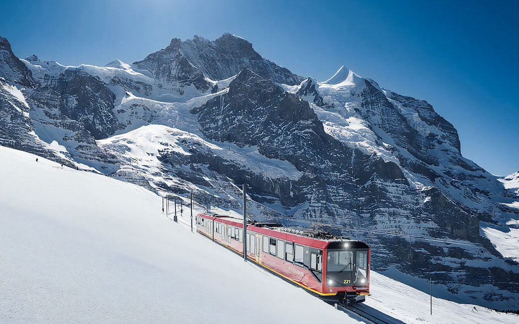 Jungfraubahn train ascending snowy Alps towards Jungfraujoch, Switzerland.
