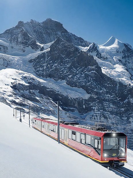 Jungfraubahn train ascending snowy Alps towards Jungfraujoch, Switzerland.