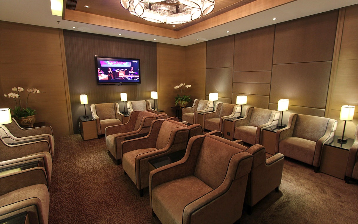 Plaza Premium Lounge seating area with armchairs and lamps, Kuala Lumpur airport.