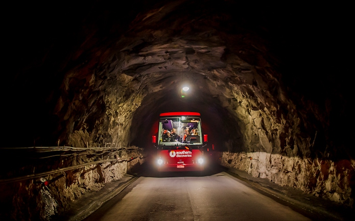 Bus traveling through Homer Tunnel towards Milford Sound.