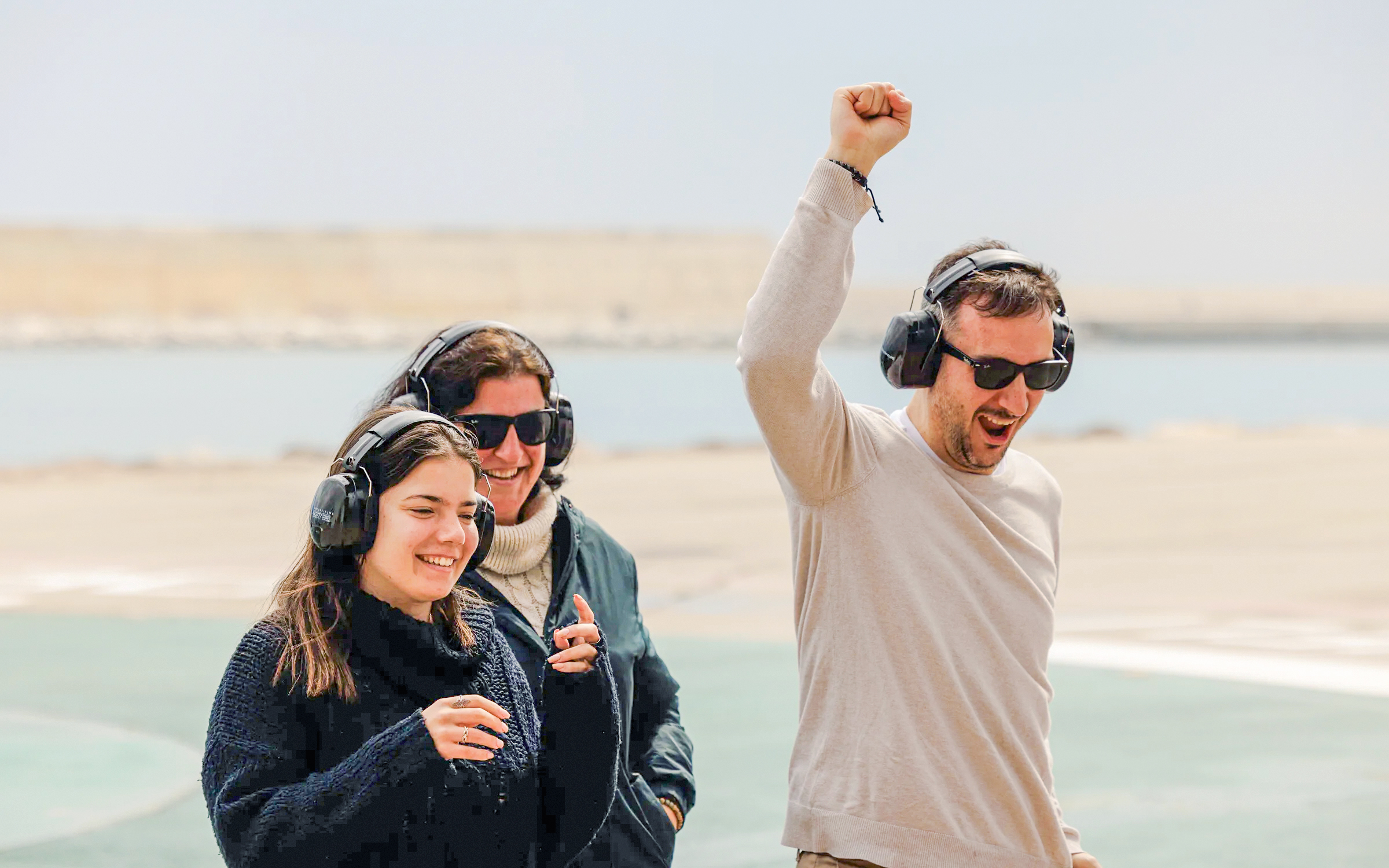 Tourists wearing headphones enjoying an outdoor experience by the water.