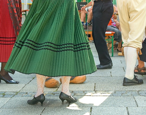 Dançarinos tradicionais apresentando polca em um vibrante festival cultural na Polônia.