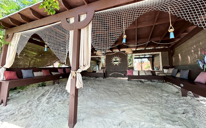 Outdoor lounge area with seating on Rose Island, part of the Swimming with Pigs day trip.