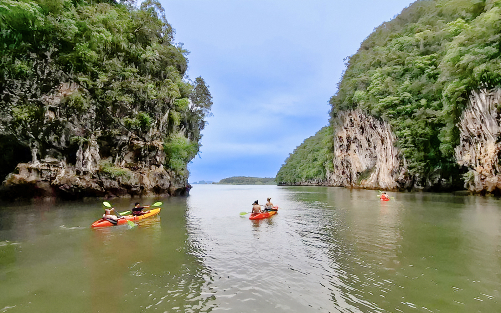 Tourists kayaking through Ao Thalane with views of Hong Islands, Thailand.