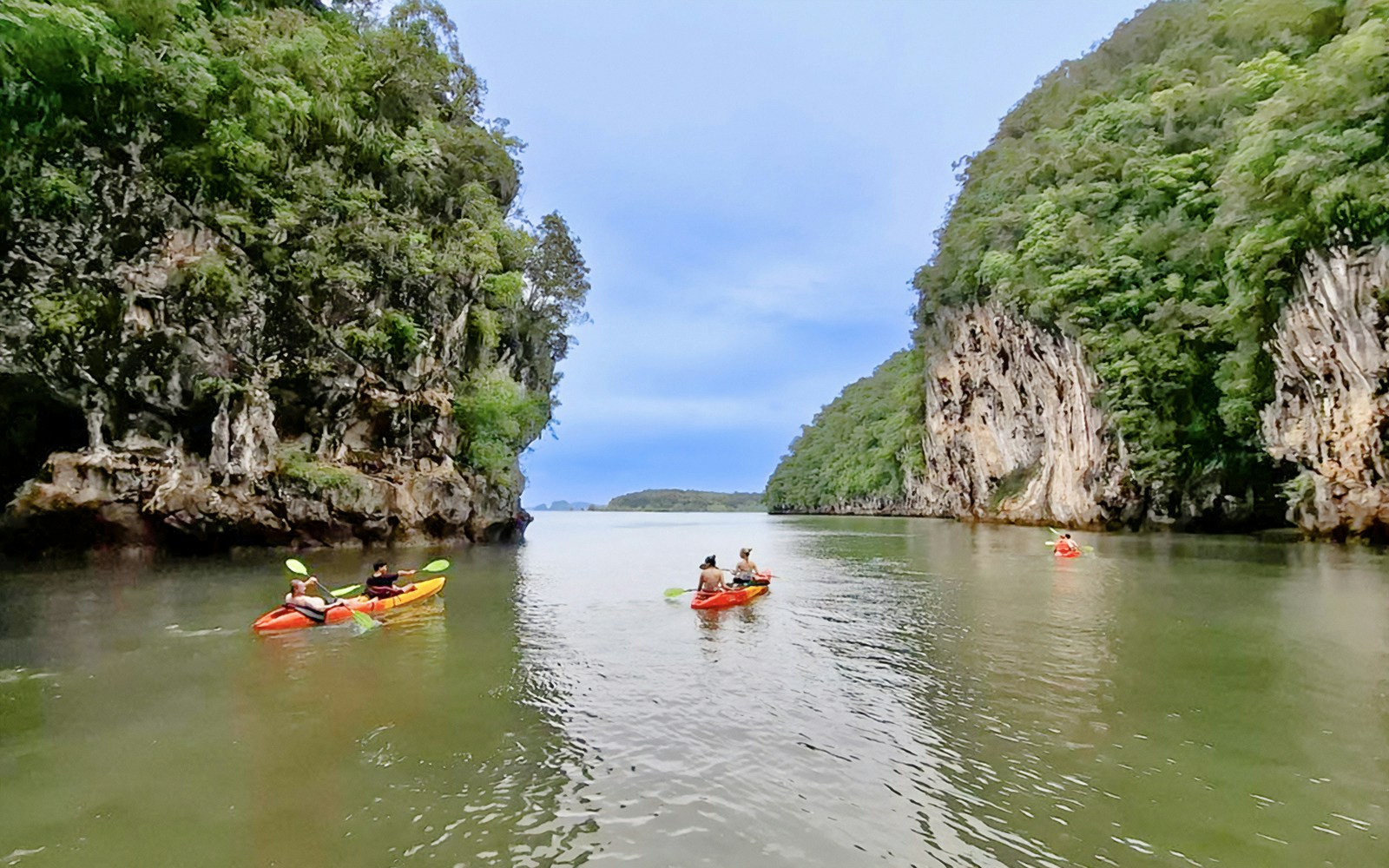 Tourists kayaking through Ao Thalane with views of Hong Islands, Thailand.