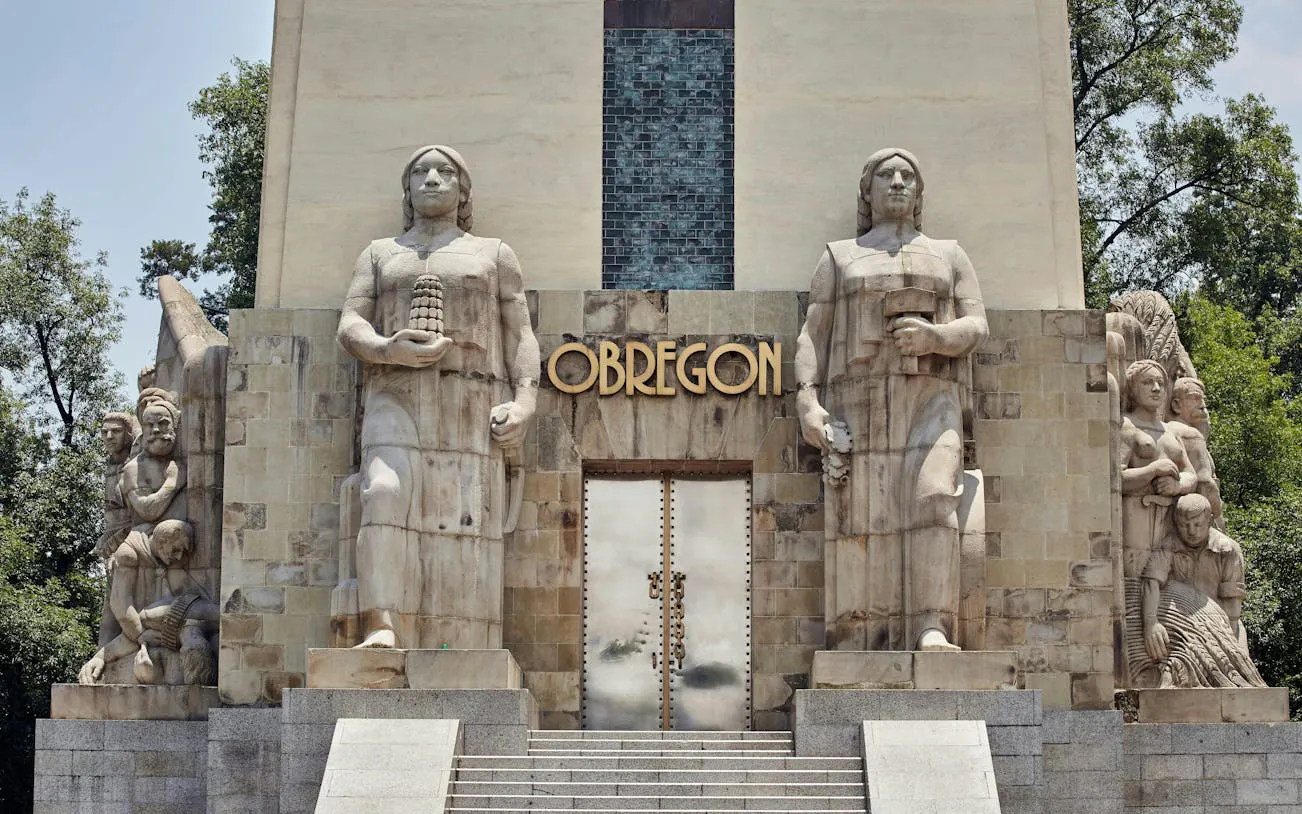 Monument with statues at Obregón site, part of Hidden Gems of Mexico City exploration game.