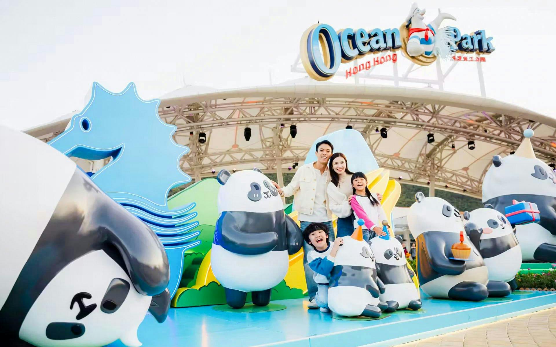 Family posing with panda statues at Ocean Park entrance, Hong Kong.