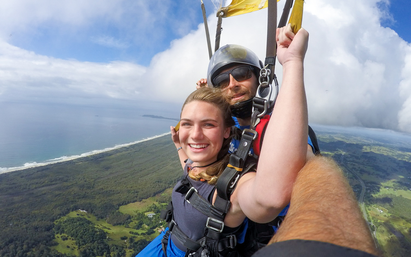 Tandem skydive over Byron Bay coastline at 15,000ft with ocean and forest views.