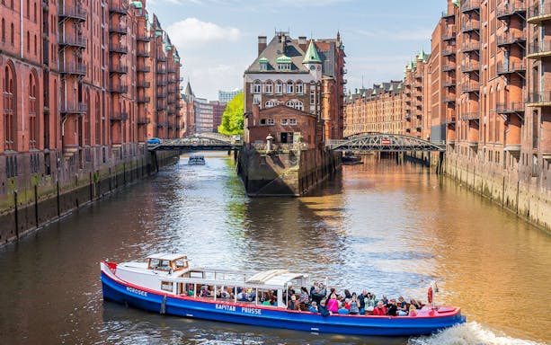 Harbor boat tour passing through historic Speicherstadt district in Hamburg.