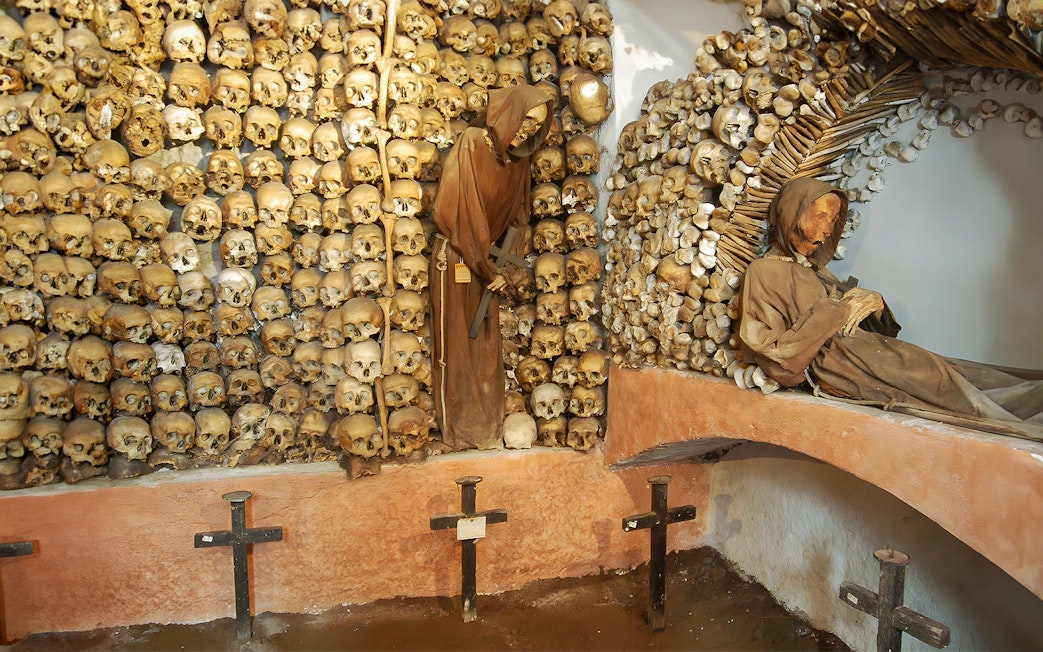 Skulls and monk figures in the Capuchin Crypt, Rome catacombs.