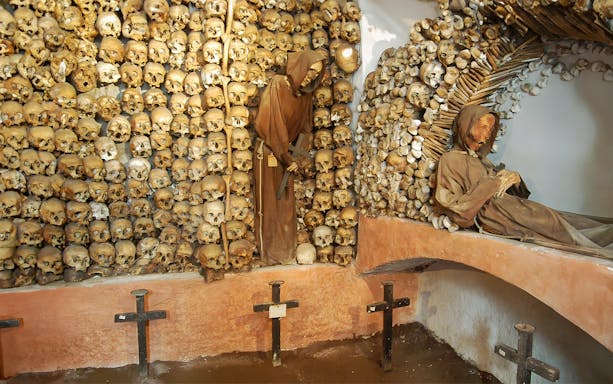 Skulls and monk figures in the Capuchin Crypt, Rome catacombs.