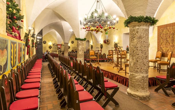 Fortress Hohensalzburg concert hall decorated for Christmas Advent event with chairs and stage.