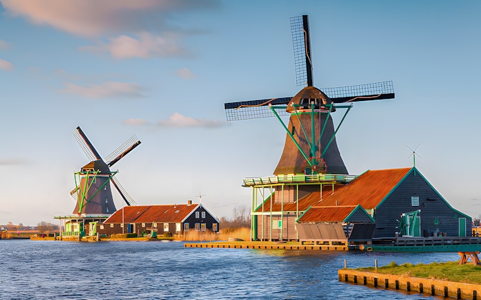 Windmills at Zaanse Schans by the water in the Netherlands.
