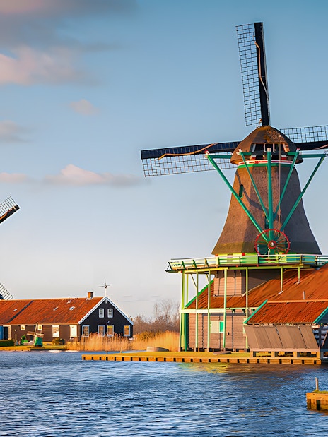 Windmills at Zaanse Schans by the water in the Netherlands.