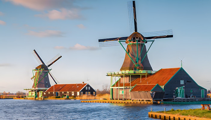 Windmills at Zaanse Schans by the water in the Netherlands.