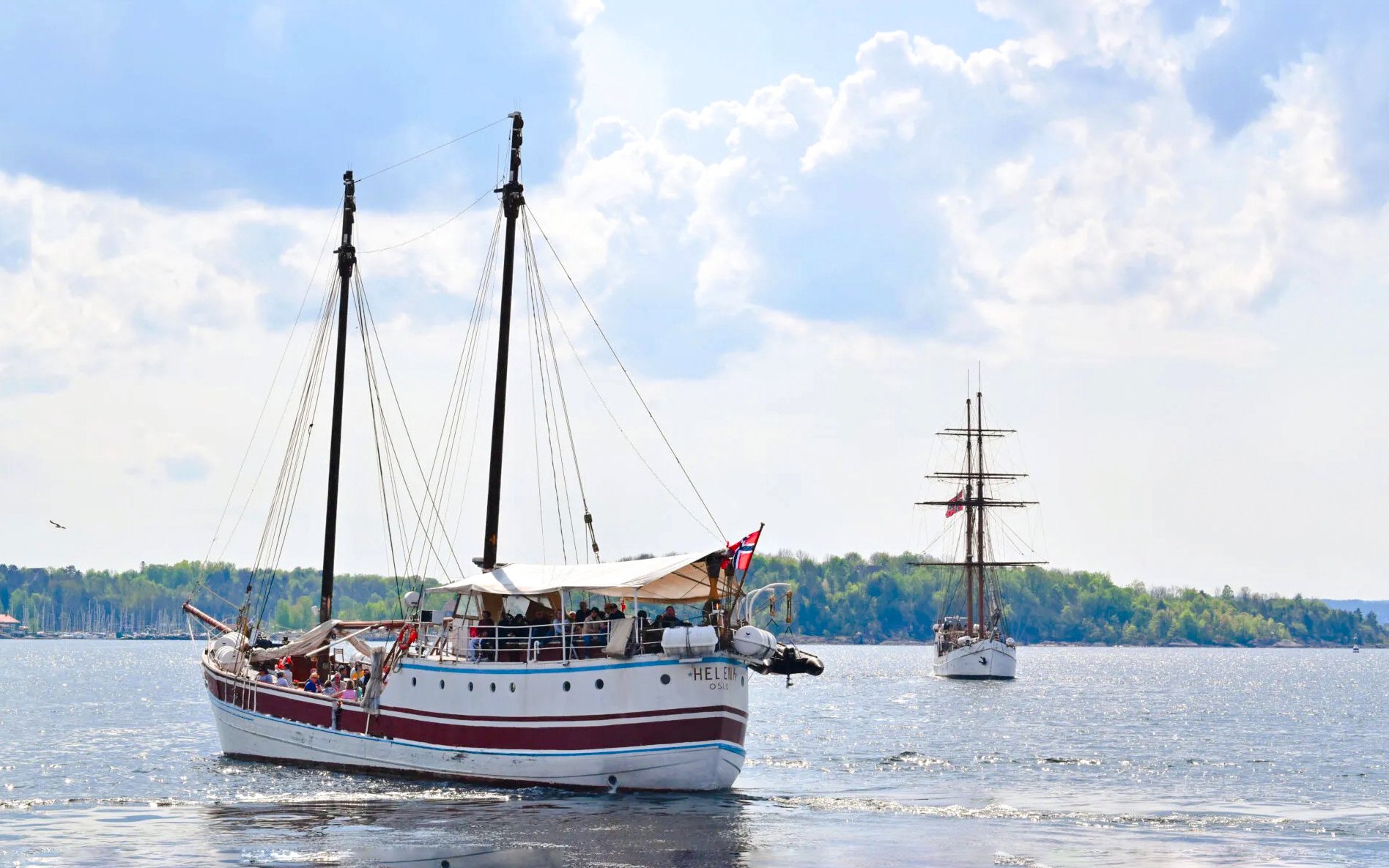 Sailing ship on Oslo fjord sightseeing cruise with distant shoreline.
