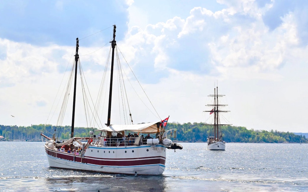 Sailing ship on Oslo fjord sightseeing cruise with distant shoreline.