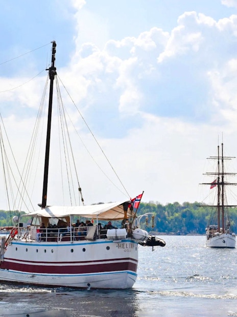 Sailing ship on Oslo fjord sightseeing cruise with distant shoreline.