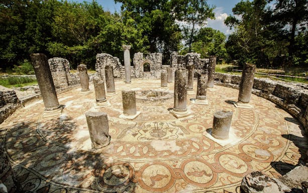 Ancient circular mosaic and columns at Butrint ruins, Albania.