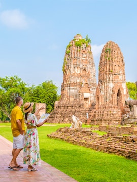 Couple exploring ancient temple ruins in Ayutthaya, Thailand.